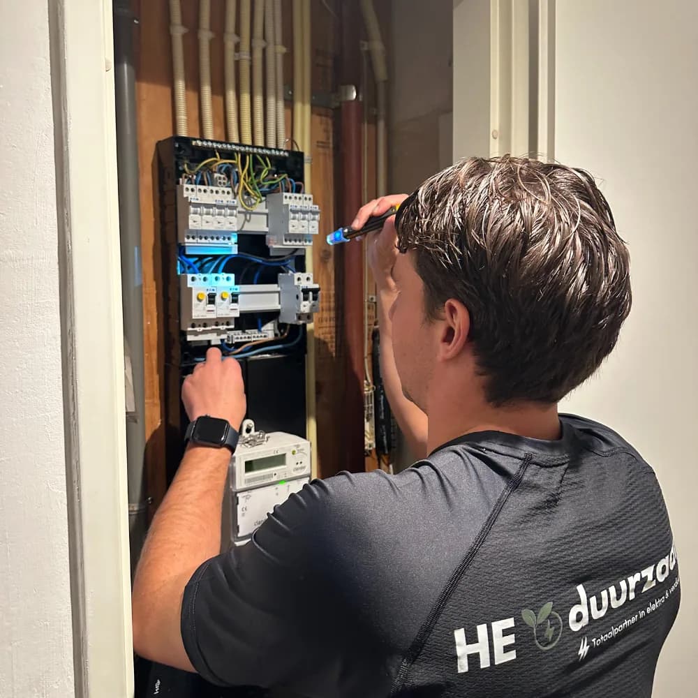 Elektricien van HE Duurzaam sluit groepen aan in een nieuwe groepenkast