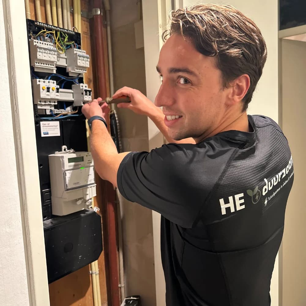 Elektricien van HE Duurzaam werkt aan een groepenkast in een meterkast