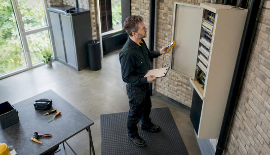 Een elektricien controleert de groepenkast op eventuele storingen of gebreken.