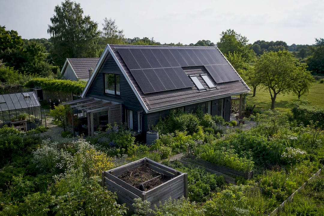 Nederlands huis met zonnepanelen en moestuinbedden